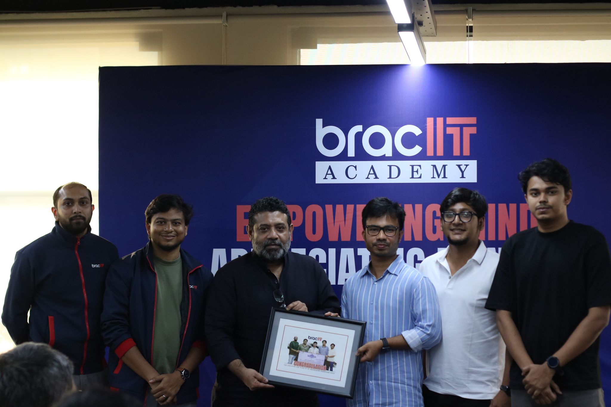 Mentors holding a framed award at the BRAC IT Academy Empowering Minds, Appreciating Mentors ceremony